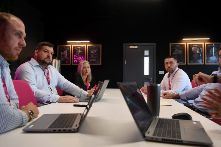 people sitting at desks with laptops