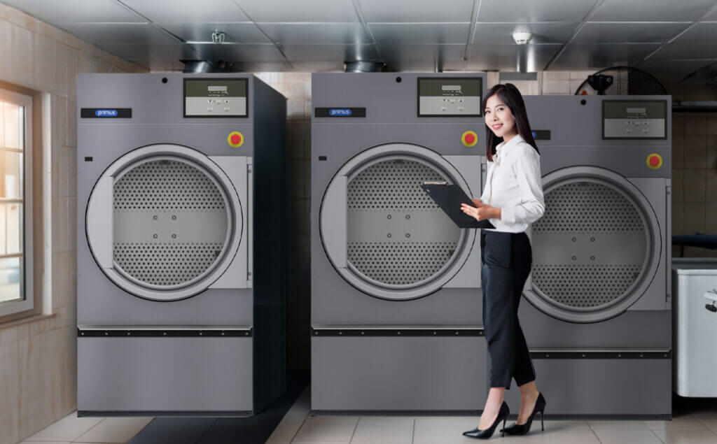 Business woman with clipboard standing in front of large industrial machines