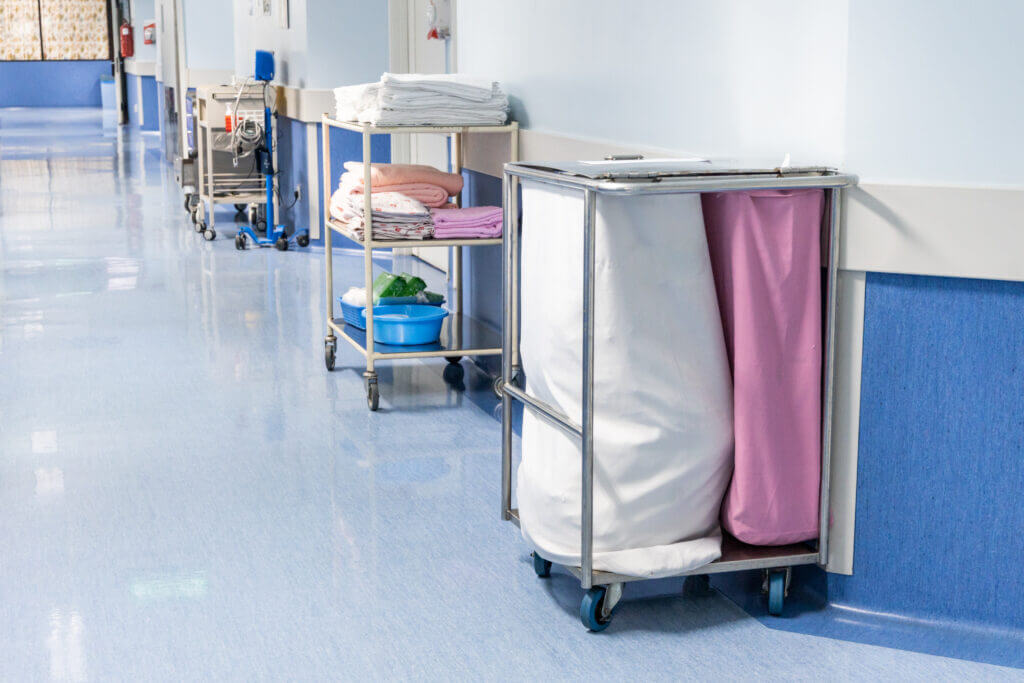 A hospital corridor with trolleys full of linens