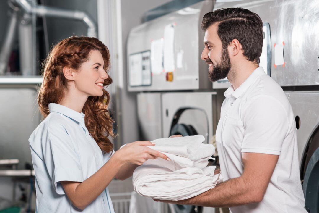 Two service wash workers folding sheets