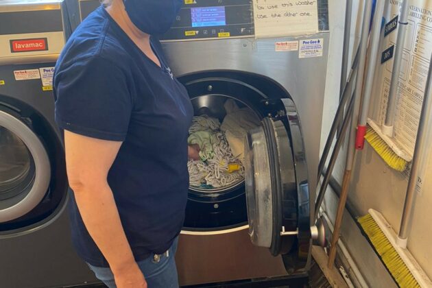A worker stood next to a commercial washing machine.